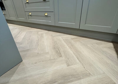 Precision integration of herringbone flooring with kitchen